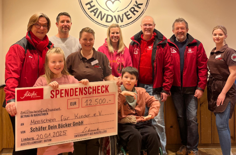 Scheck über 12.500 € an Menschen für Kinder e.V., Gruppe mit Kindern.